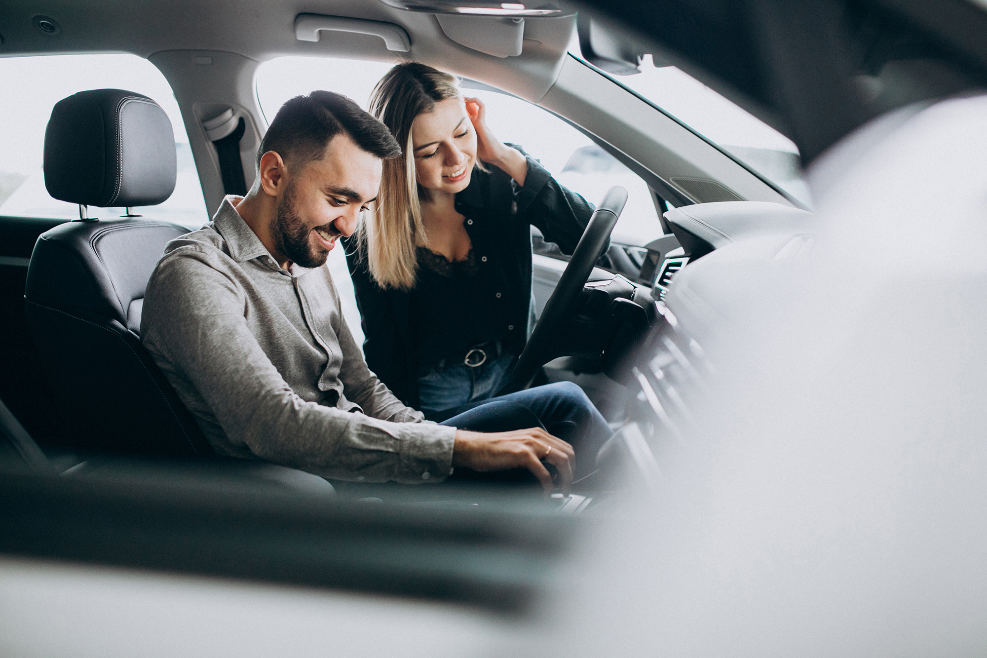 Dvoje ljudi razgledaju unutrašnjost automobila pri izboru vozila